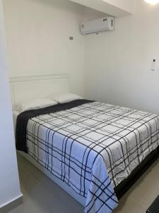 Monte PlataPlataview Apartahotel 3B的一间卧室配有一张带蓝白色毯子的床