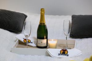 维也纳Pension Lovac 10的床上的一瓶香槟和两杯酒