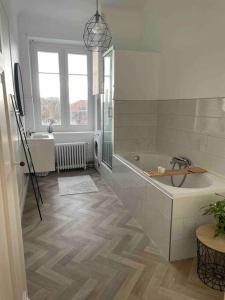 图尔昆Grand appartement charmant à 10 min de Lille的白色的浴室设有浴缸和水槽。