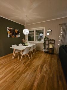 特罗姆瑟Aurora apartment in Kvaloya Tromso的一间配备有白色桌椅的用餐室