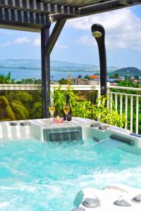 莱特鲁瓦西莱Villa Sweet Caraïbes, vue mer, jacuzzi的热水浴池,内含2杯葡萄酒