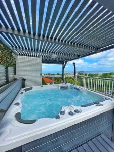 莱特鲁瓦西莱Villa Sweet Caraïbes, vue mer, jacuzzi的甲板上的热水浴池,带凉棚