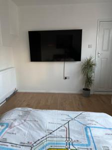 伦敦Self-contained en-suite room in Wembley的墙上配有平面电视的房间