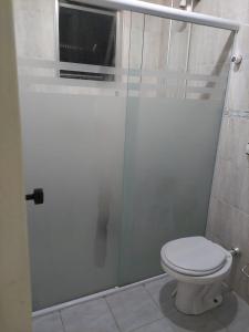 索莱马Cantinho de vó - Praia Grande - Aviação的一间带卫生间和玻璃淋浴间的浴室