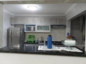 索莱马Cantinho de vó - Praia Grande - Aviação的厨房配有水槽和冰箱