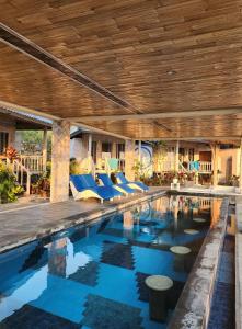 蓝梦岛Nusa View的一个带蓝色椅子和木制天花板的游泳池