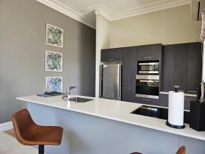 基督城Aspiring Villa Apartment的厨房配有带水槽和椅子的柜台