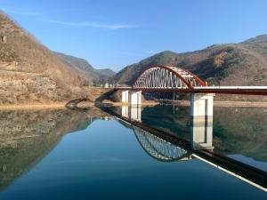 丹阳Danyang Rio 127 Guesthouse的河上一座桥,在水中反射