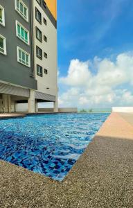 瓜拉丁加奴Inap Tanjung Homestay的一座酒店,在一座建筑旁边设有游泳池