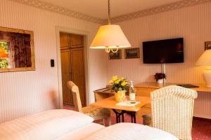 基姆湖畔普林莱因哈特花园酒店的一间设有桌子、床和电视的客房