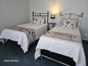PhilippolisThe Witch's Inn的两张带白色床单和枕头的床。