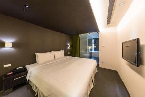 台北凡登台北商務旅店的一间卧室配有一张大床和电视