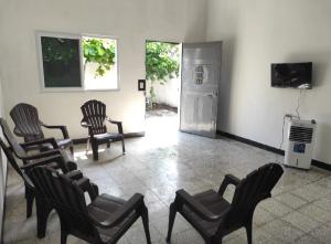 圣何塞港Casa de descanso Grace的一间带椅子、冰箱和电视的房间