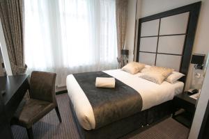 伦敦大圣海伦酒店的一间卧室配有一张床、一张桌子和一把椅子