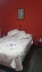 Bella UniónHotel Bella Unión的卧室配有白色的床铺和红色的墙壁