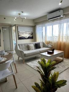 伊洛伊洛Spacious 3 Bedroom Appartement @Avida Allgauers的客厅配有沙发和桌子