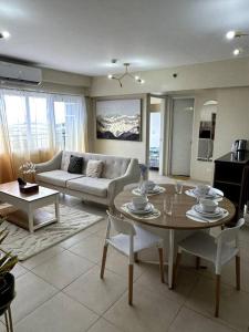 伊洛伊洛Spacious 3 Bedroom Appartement @Avida Allgauers的客厅配有桌子和沙发