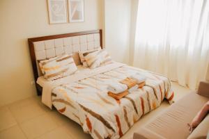 伊洛伊洛Spacious 3 Bedroom Appartement @Avida Allgauers的一间卧室配有带毛巾的床