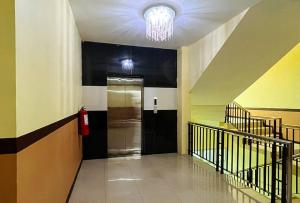 安吉利斯RedDoorz at Diamond Spring Hotel Angeles City的走廊上设有黑色的门和吊灯