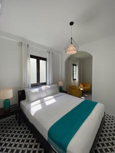 琅勃拉邦Fides Boutique Hotel的一间卧室配有一张大床和一个吊灯。