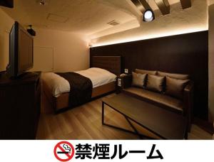 名古屋Hotel LALA - Kitashiga - (Adult Only)的客房设有床、沙发和电视。