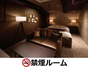 名古屋Hotel LALA - Kitashiga - (Adult Only)的酒店客房,配有床和沙发