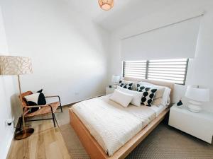 圣胡安Stylish Comfy Boho Style Home W/ Parking@ San Juan的一间卧室配有一张带灯和椅子的床