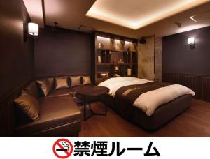 名古屋Hotel LALA - Kitashiga - (Adult Only)的一间卧室配有一张床和一张沙发