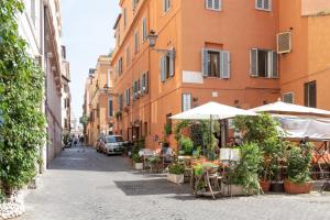 罗马Elegant & Quiet Apartment next to Colosseo的街上带桌子和遮阳伞的小巷