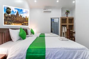 暹粒The Khmer House Villas的卧室配有绿色和白色的大床