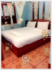 Muang KhôngMR Mo Guest House的一间卧室配有一张带白色床单的大床