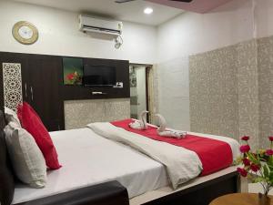 珀勒德布尔Hotel Pratap Palace的一间卧室配有一张大床,上面有两个天鹅