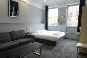 凯特林Royal Hotel Kettering的一间卧室配有一张床和一张沙发