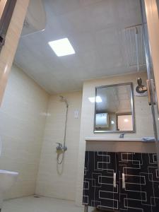 广州美居公寓酒店的带淋浴、盥洗盆和镜子的浴室