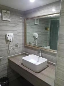 广州美居公寓酒店的浴室设有白色水槽和镜子