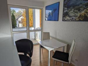 罗斯多夫Ruhige, moderne Wohnung bei Darmstadt in Roßdorf的客房设有桌椅和窗户。