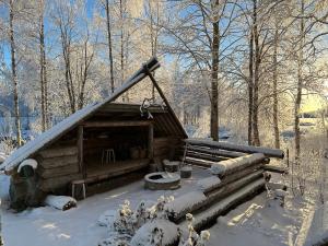 MeltosjärviRow house in Meltosjärvi的小木屋,设有雪盖屋顶