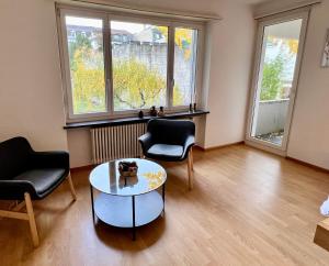 巴塞尔Gemütliche Wohnung Nähe Uni的客厅配有两把椅子和一张桌子