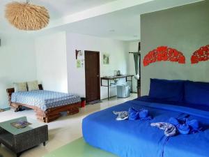麦岛Good Time Sports Village Koh Mak的一间卧室配有一张蓝色的床和一张桌子