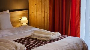 NapareuliVineyard Hotel & Winery的一间卧室配有一张带白色床单和一盏灯的床。