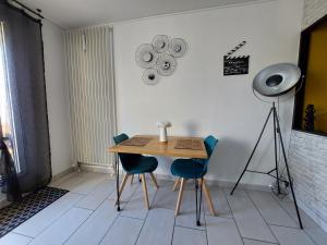 穆兰Studio sur les rives d'allier的一张桌子和椅子,位于带摄像机的房间