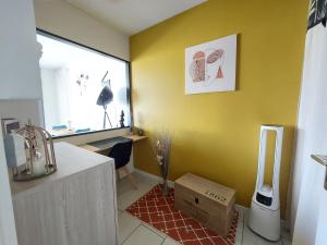 穆兰Studio sur les rives d'allier的厨房设有黄色墙壁,地板上设有盒子