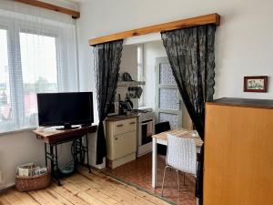 梅图耶河畔新城Slunný byt s krásným výhledem的客厅配有电视和带桌子的书桌。