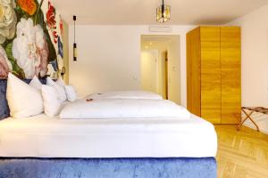 拜尔施泰因利普曼克洛斯达伯格酒店的卧室配有一张白色大床,墙上挂有绘画作品