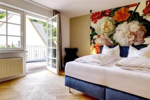拜尔施泰因利普曼克洛斯达伯格酒店的一间卧室配有一张带花卉墙壁的床