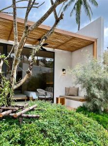 芭东海滩Eden Resort & Villas的现代房屋设有庭院和树