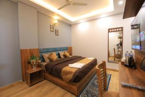 瑞诗凯诗Hotel Mahadev Rishikesh的一间卧室配有一张床和一台电视