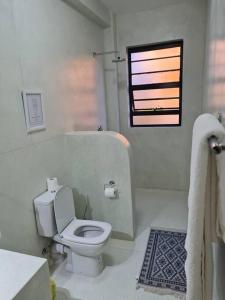纳纽基The Landing Cottages的白色的浴室设有卫生间和窗户。