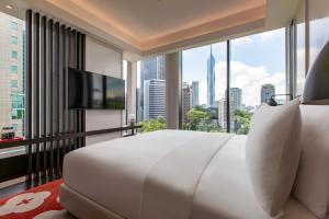 吉隆坡Hotel Indigo Kuala Lumpur on the Park, an IHG Hotel的卧室设有一张白色大床和大窗户