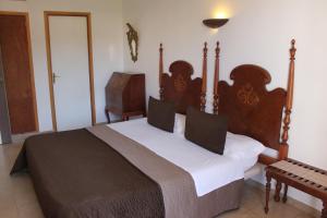 安德莱奇港卡塔利娜韦拉酒店的一间卧室配有一张大床和木制床头板